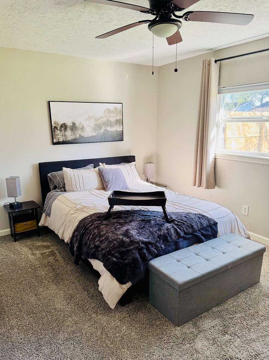 Primary bedroom with a queen bed, 2 closets, a small dresser, and a desk. 
