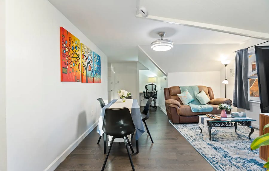 Bright dining area with a table for four and vibrant artwork. 
