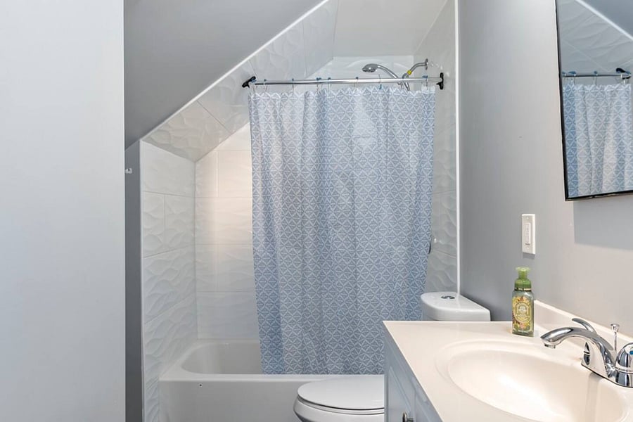 The bathroom has a shower-tub combo, perfect for relaxing baths or quick showers, and a large vanity. 