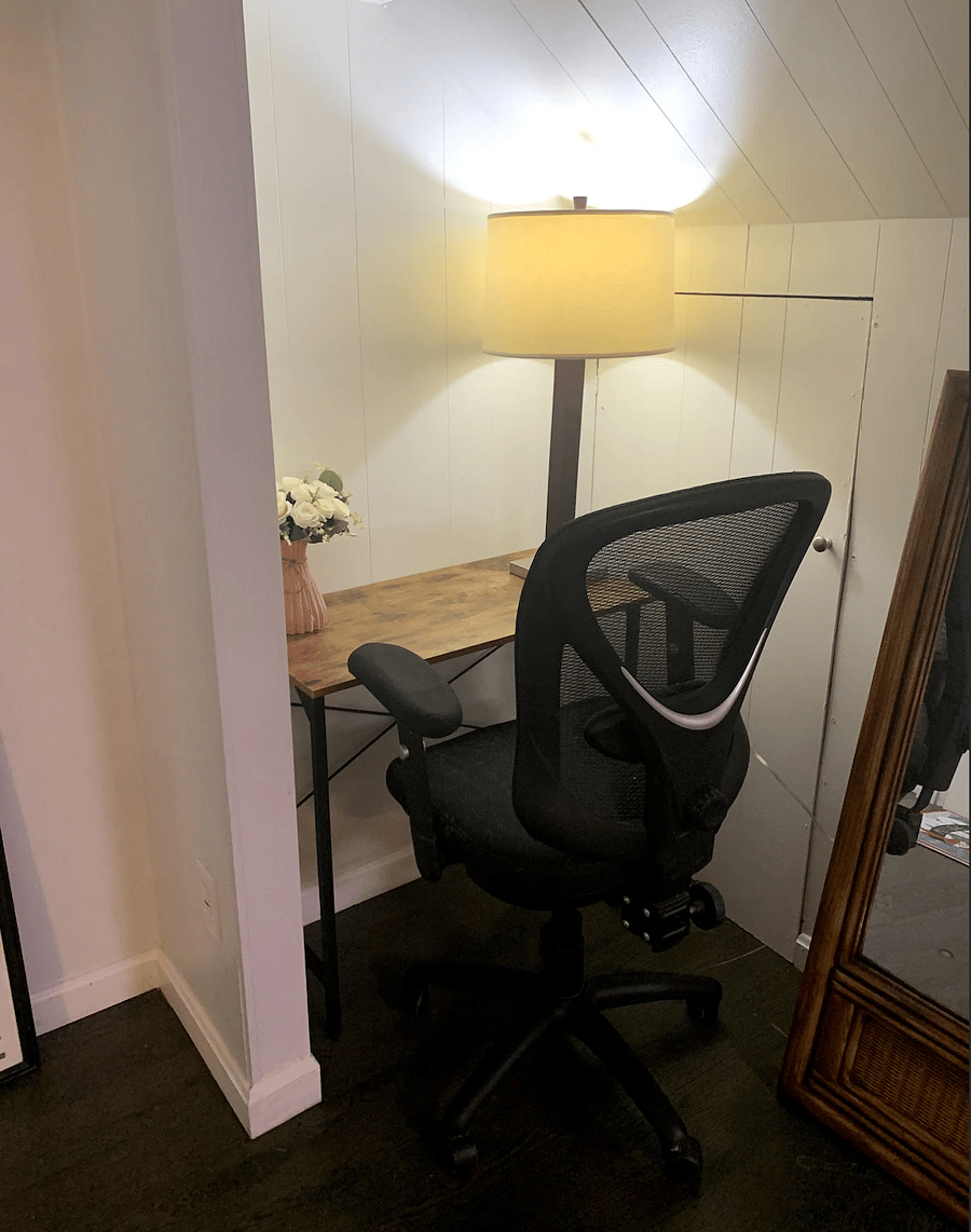 Compact workspace with a comfortable chair and a lamp for extra lighting. 