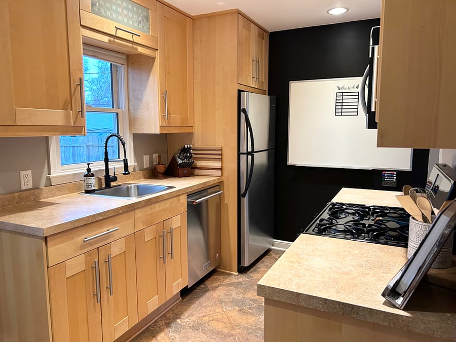 Fully stocked kitchen with essentials and stainless steel appliances (microwave, fridge, dishwasher, stove/oven).