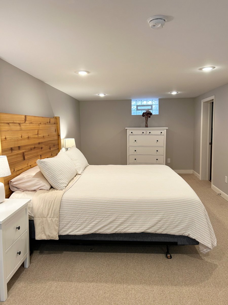 Spacious lower level bedroom featuring a king sized bed and a tempur-pedic mattress for the best night of sleep! Door to bathroom is on the right side.