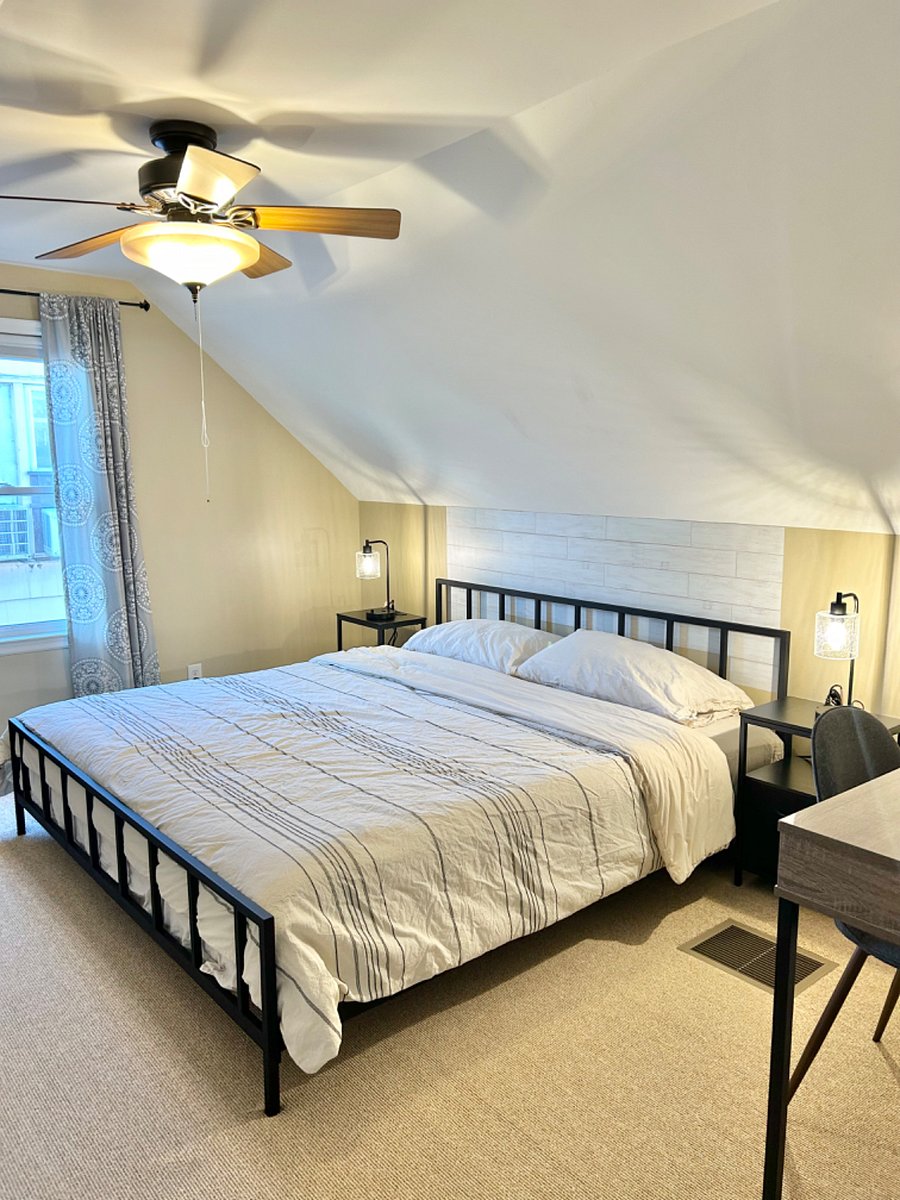 Upstairs bedroom featuring a king sized bed, dresser, walk-in closet and desk area.