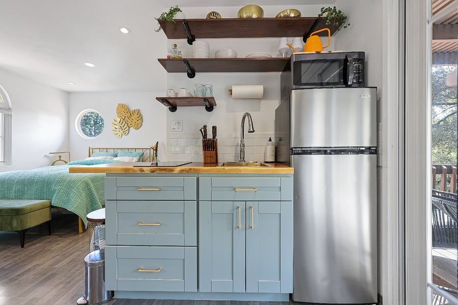 Kitchenette with double burner stove for your cooking needs complete with pots, pans, knives, utensils, plates and glasses.