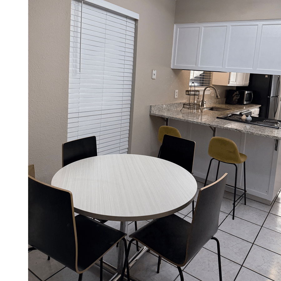 breakfast area with table and 4 chairs, 2 additional chairs at countertop.