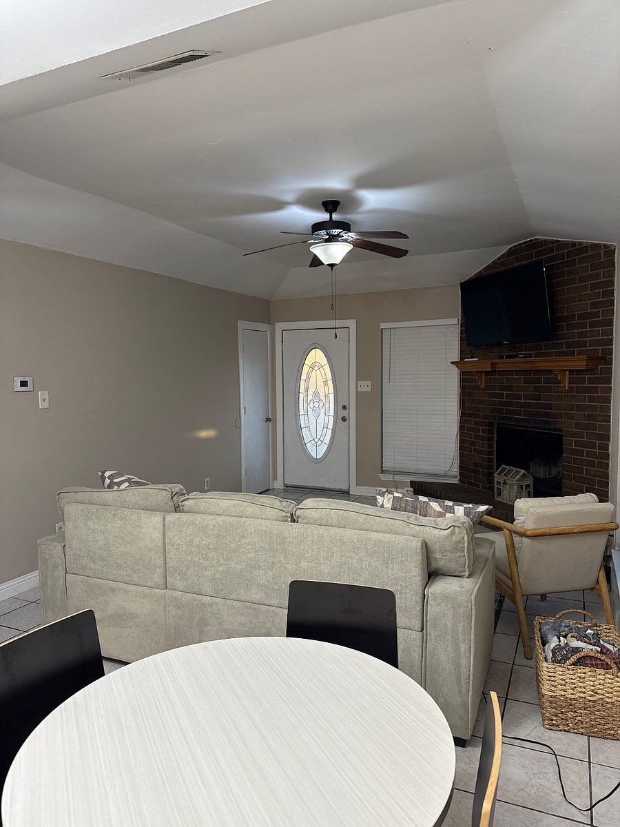 picture from breakfast area to front door. Living room, TV mounted above fireplace.