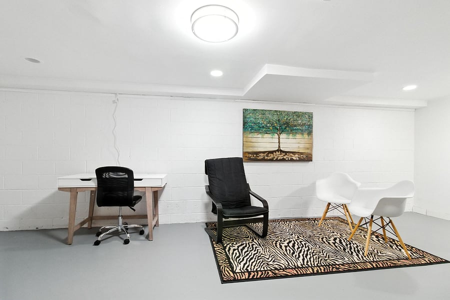 Seating in the unfinished basement includes a desk with adjustable chair.
