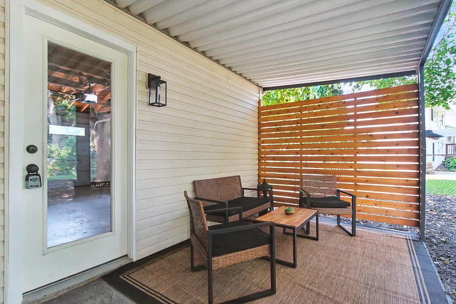 The covered patio off the garage has seating for four.