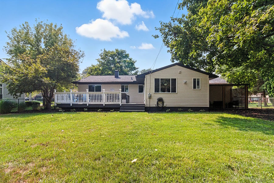 Rear of home with large deck and covered patio.