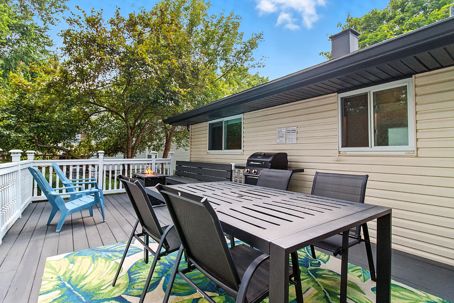 The large deck has a dining set for four, a BBQ grill, and a firepit with seating for five.