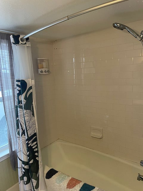 Shower/bath combo with moveable shower head complete with soap, shampoo and conditioner dispenser.
