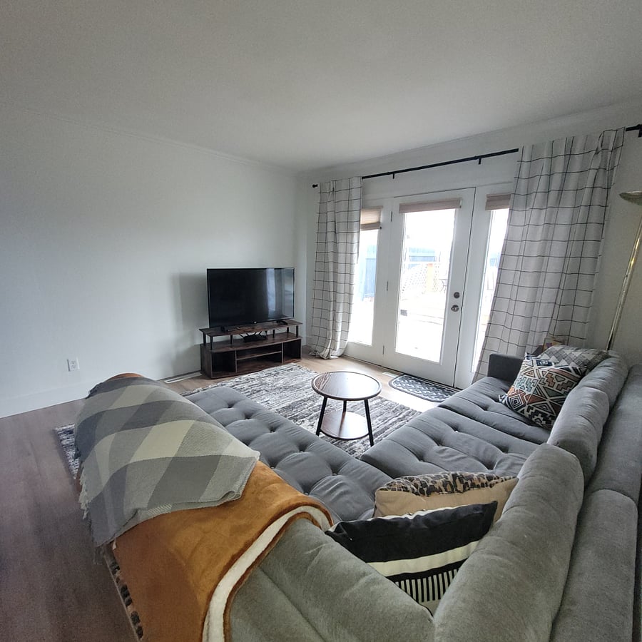 Large sofa, charging port, smart TV and outdoor access from living room.