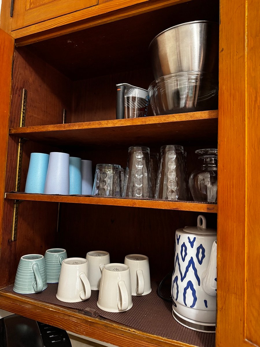 fully stocked cups, mixing bowls, and tea kettle.
