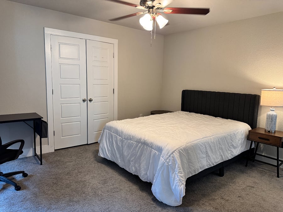 BEDROOM 2 with ensuite bathroom features a queen bed, desk and chair and spacious closet