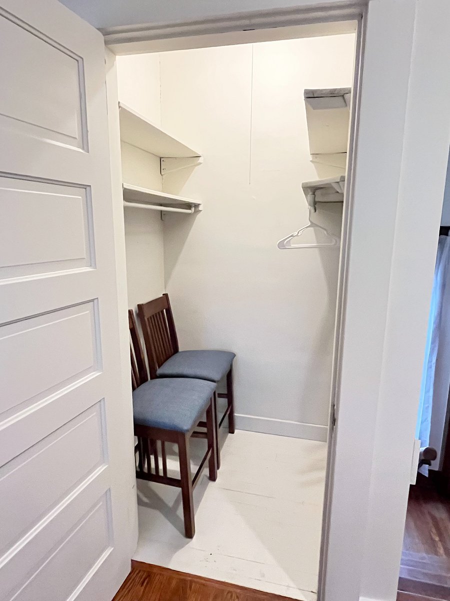 oversized walk-in hall closet with extra dining chairs and plenty of hangers