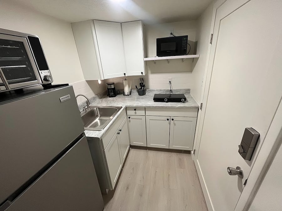 Kitchen offers a refrigerator, 2 burner stove, countertop oven, microwave, coffee maker, blender and all pots, pans, dishes