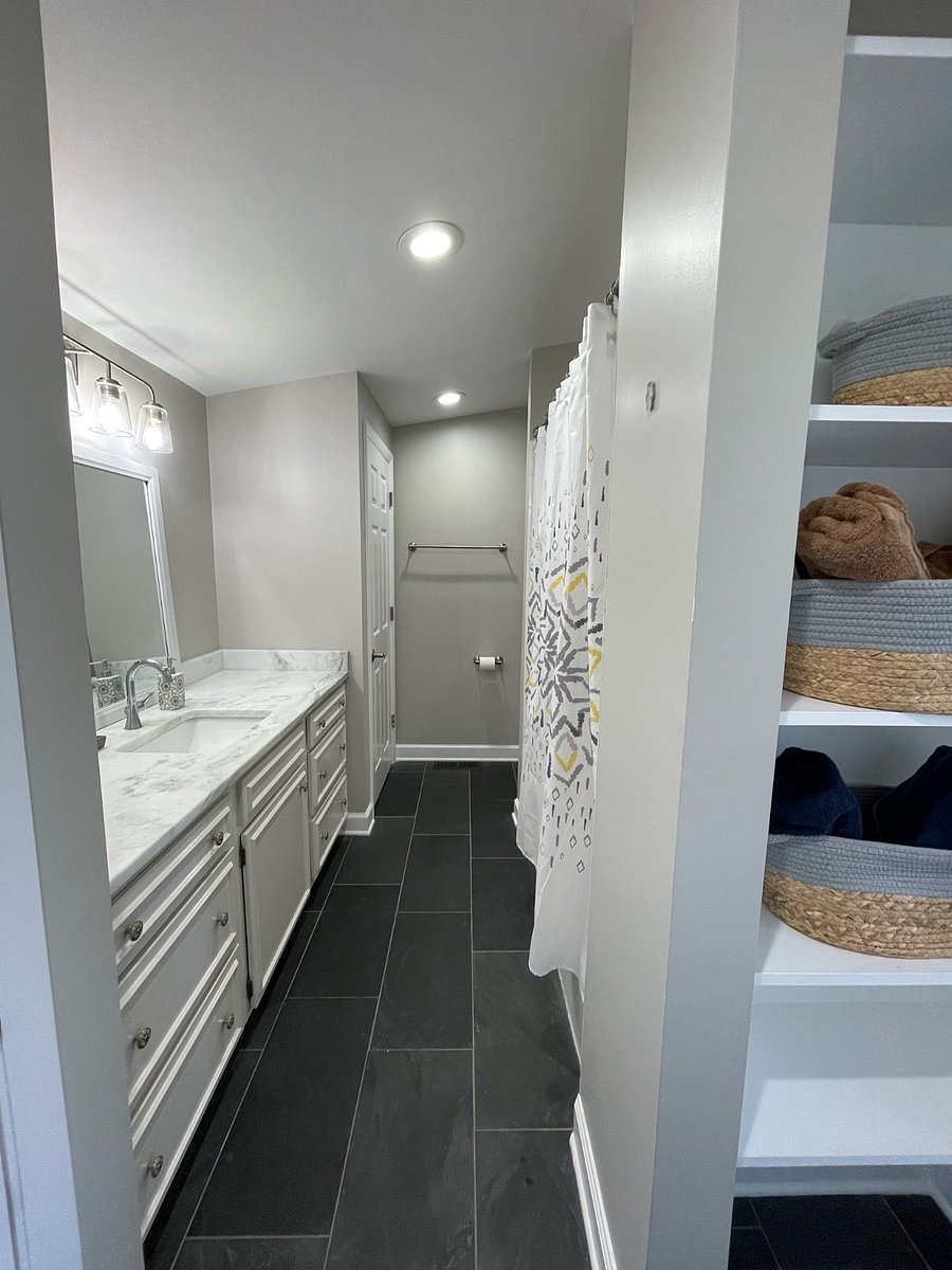 Bathroom with oversized marble vanity. Closet and large cabinets and shelving for additional storage