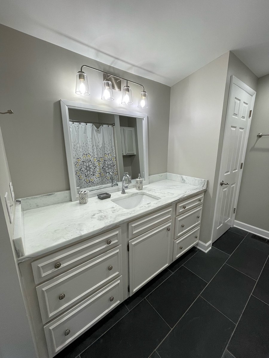 Bathroom with oversized marble vanity. Closet and large cabinets and shelving for additional storage