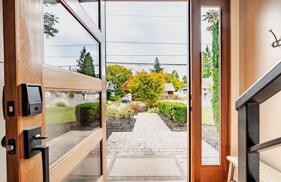 Front door opens to a sizable front yard with lawn space and a landscaped gharden.