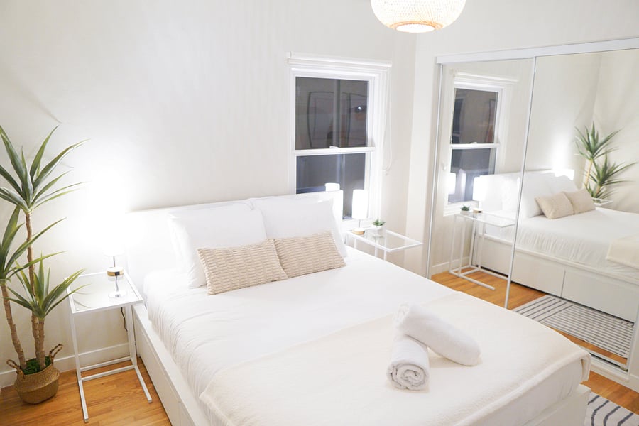 Another view of the second bedroom with a large mirrored closet and under the bed drawers