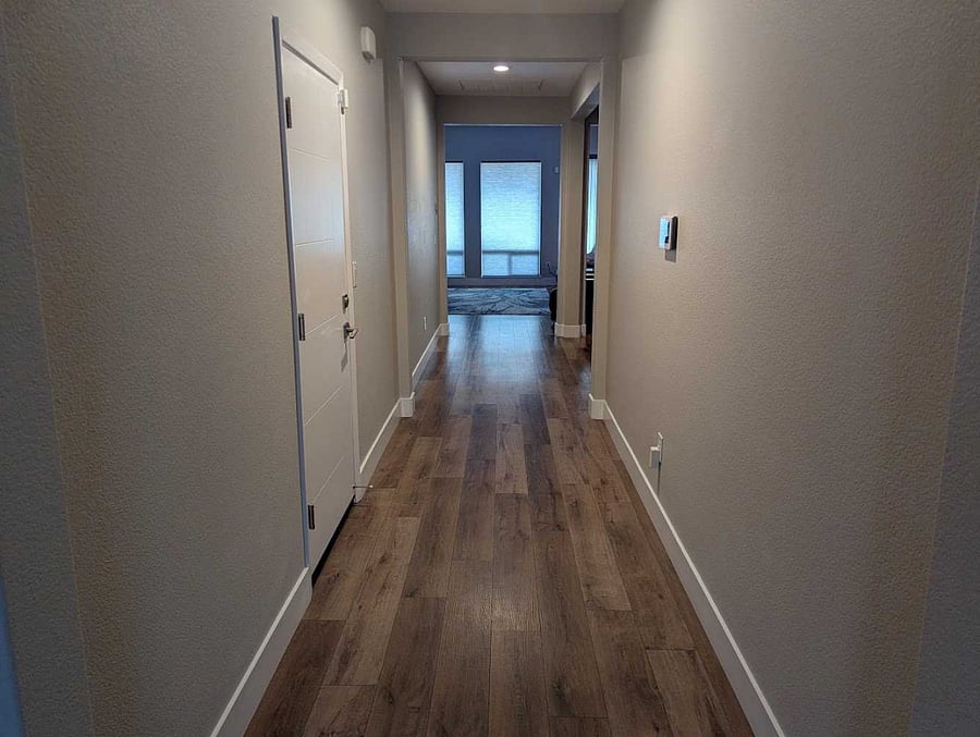 WIDE HALLWAY WITH ADT CONTROL PANEL ON THE WALL
