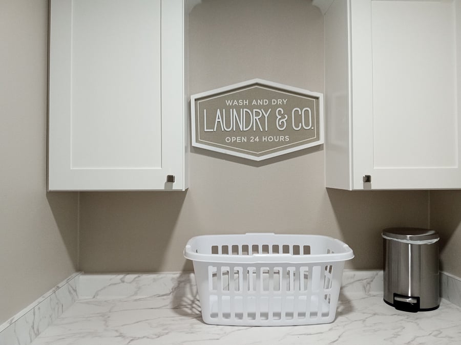 Laundry room with laundry soap, folding table, cabinets, ironing board, iron, and cleaning tools
