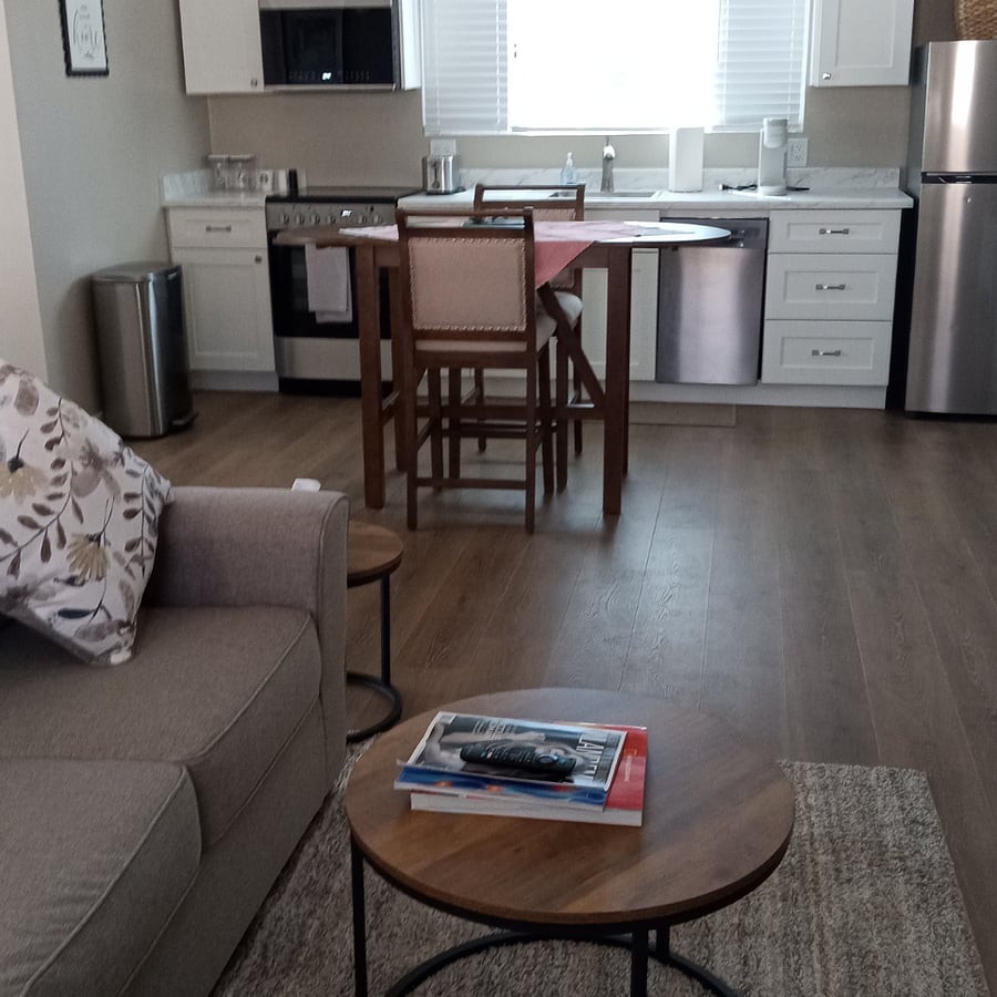 Looking toward the kitchen from the Living room. Dining room table with two stools, can alway double as a desk or work station.
