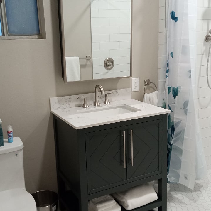 Bathroom with roll in shower, large medicine cabinet behind mirror, doors under vanity Shelves under cabinet. Toilet. All new!