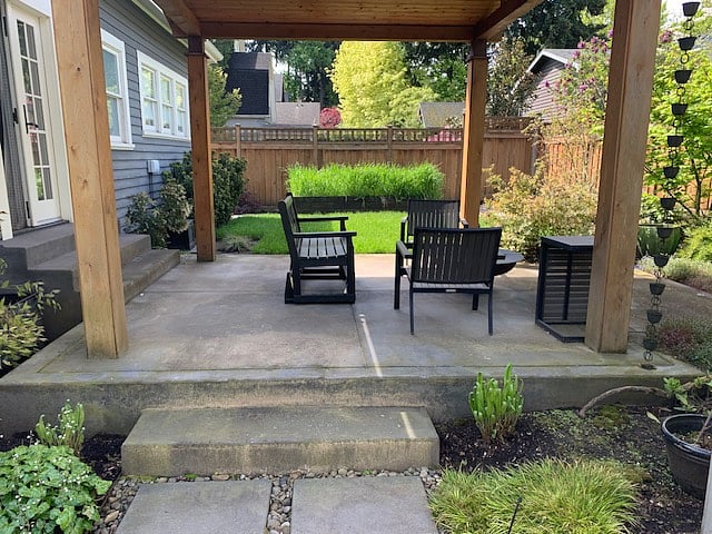 Pergola has a year-round gas firepit. Raised vegetable beds visible on far side of pergola. 