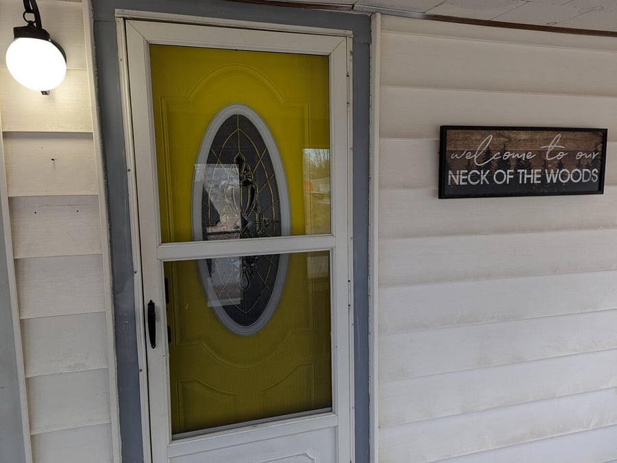 Front door inside of an enclosed porch.