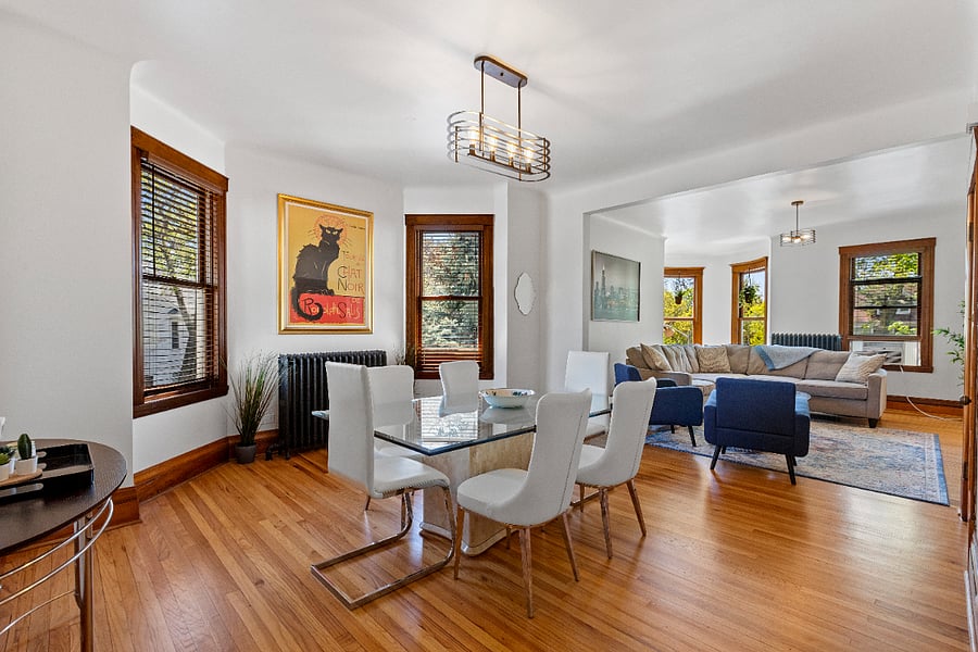 Step into a bright and airy formal dining room, where natural light pours in to highlight the elegant white leather and glass dining set. Thoughtfully curated artwork and lush greenery add a touch of sophistication and warmth, creating the perfect setting for memorable meals and gatherings.
