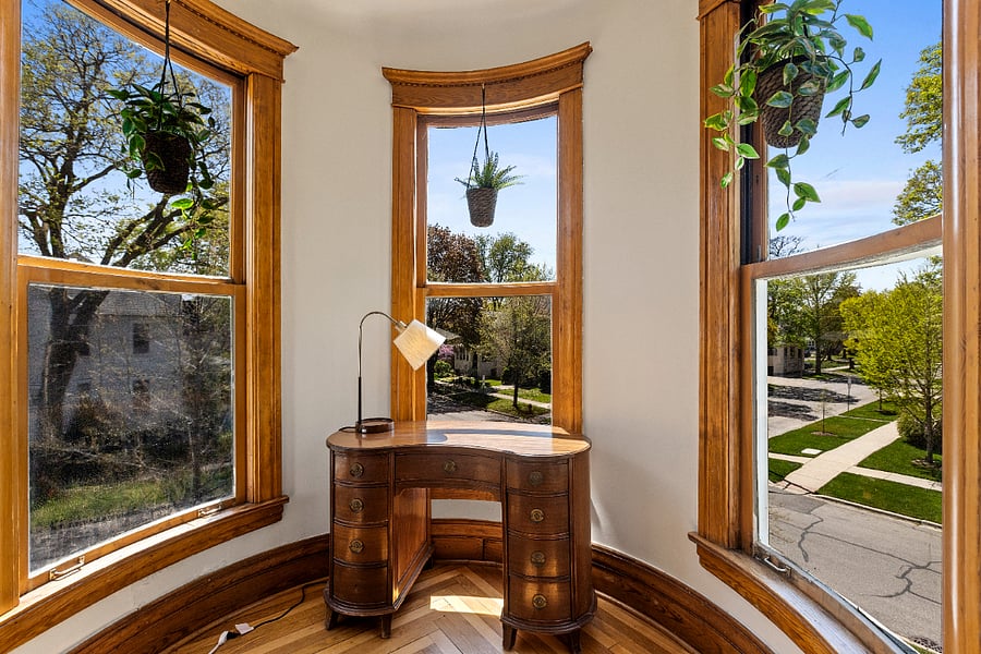 This exquisite kidney-shaped antique desk, a treasured family heirloom, has found its perfect place in the turret, offering a unique and inspiring workspace with views of the corner. Its one of two thoughtfully designed workstations, blending timeless charm with modern functionality.