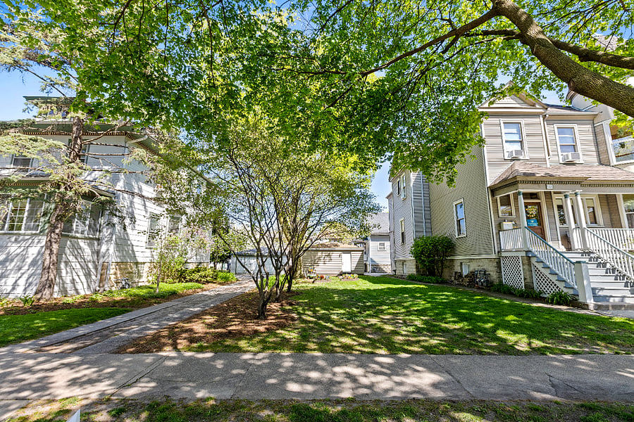 Nestled on a double corner lot along a beautiful tree-lined street, this side lot offers a serene escape. Gather around the firepit as the kids enjoy the sandbox, or take in the peaceful sounds of resident cardinals and the charm of the windmill garden. Keep an eye out for the playful bunnies that often grace the area, adding to the tranquility and natural beauty of the space.