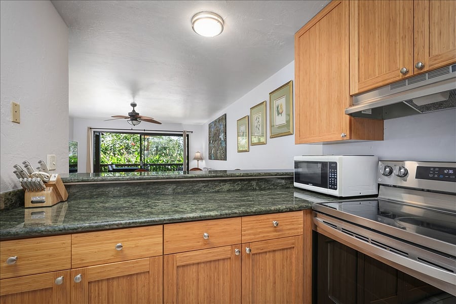 Open style kitchen looking into living room & garden. Newly renovated with stainless steel appliances, dishwasher, fridge, bamboo cabinets, marble counter tops, and all the cooking supplies you need to create a feast!