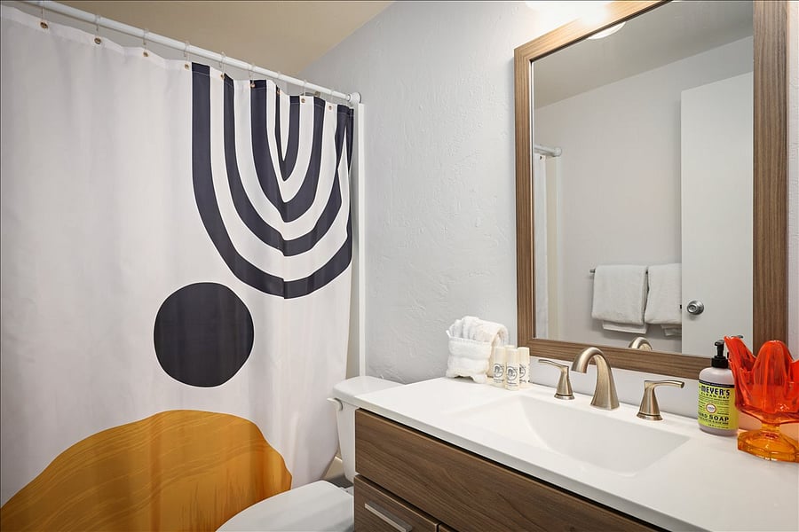 Large bathroom in hall with full size bath tub & shower.