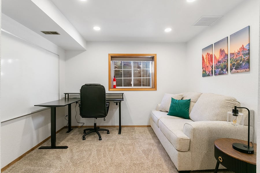 At home workstation with desk for computers, a white board for brainstorming or task management, and a comfy couch to boot!