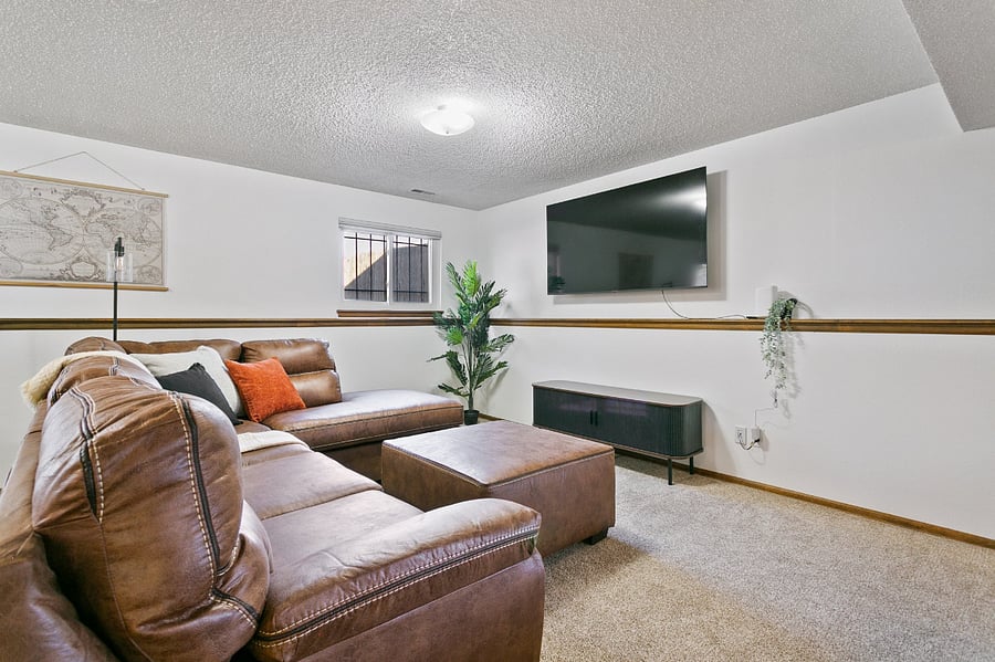 Living room with sectional couch and large 70 inch TV