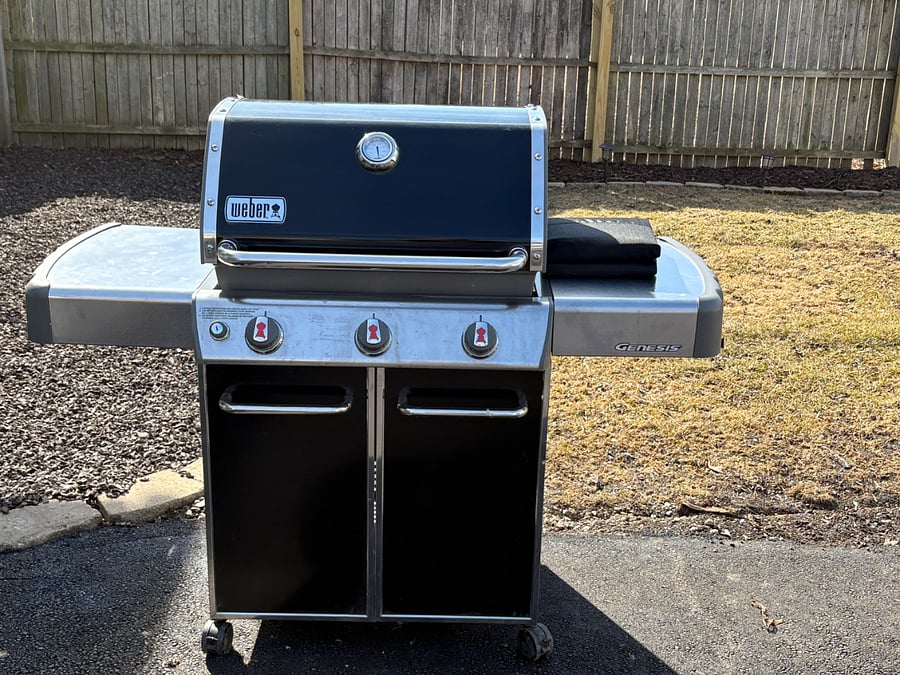 Weber grill with one canister of propane provided. Grill tools in kitchen.