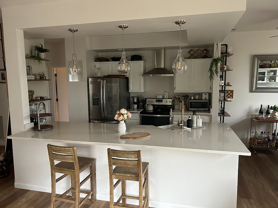 Kitchen view from the living room. Pearl Quartz countertop. W/raisable embedded charging station. Farm sink and hood were added to the other 2 new stainless steel appliances Fridge & Dishwasher.