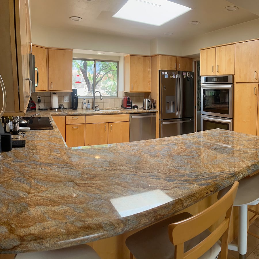 Kitchen and breakfast bar with double oven, cooktop and dishwasher.