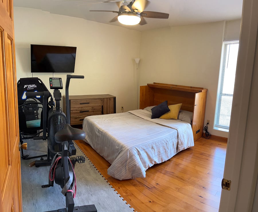Third bedroom with Murphy cabinet bed and exercise bike