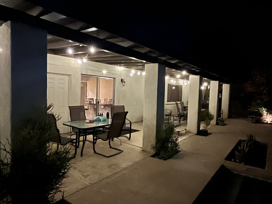 Pool deck with Edison bulbs and a table ready for family games.