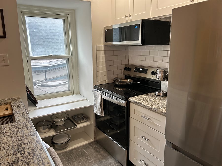 Kitchen area with microwave, stove top, and oven, refrigerator, quartz countertop.
Studio apartment (#3)