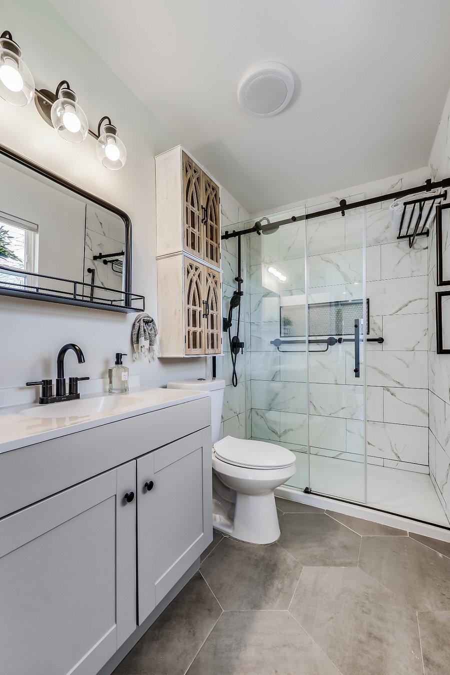 Walk in tiled shower with sliding glass door.