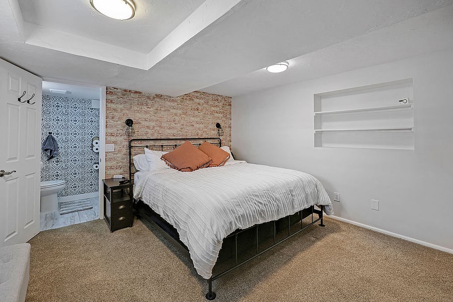 Bedroom # 1-King Bed, Smart TV, Closet space with shelf, hangers, fan, heater, extra blanket. 4 drawer dresser. Dimmable lamps and charging stations on each side of bed. Plantation shutters allow for light or darkness in the room. Large window North facing window. Most of window above ground. Has attached half bath.