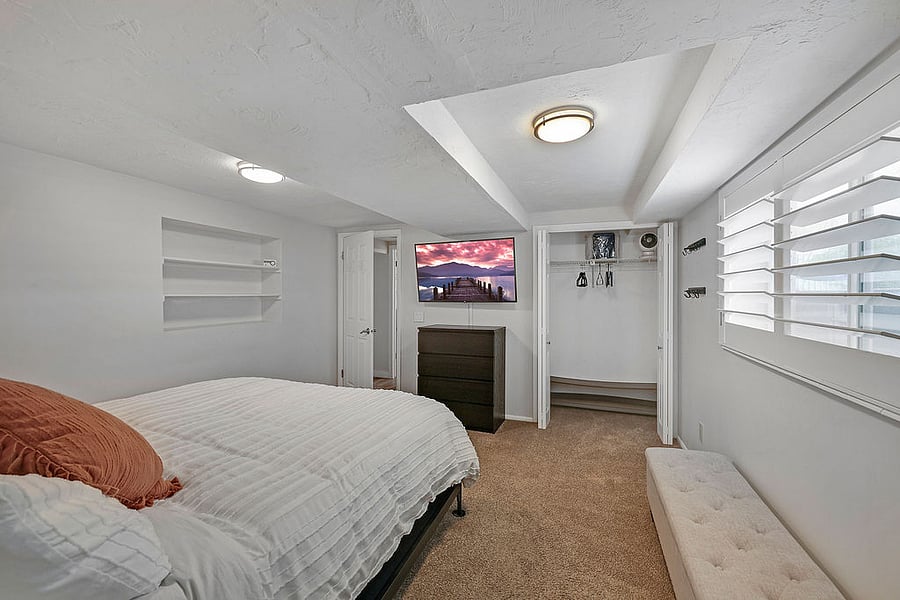 Bedroom # 1-King Bed, Smart TV, Closet space with shelf, hangers, fan, heater, extra blanket. 4 drawer dresser. Dimmable lamps and charging stations on each side of bed. Plantation shutters allow for light or darkness in the room. Large window North facing window. Most of window above ground. Lets in light similar to a walk out basement view. Has attached half bath.