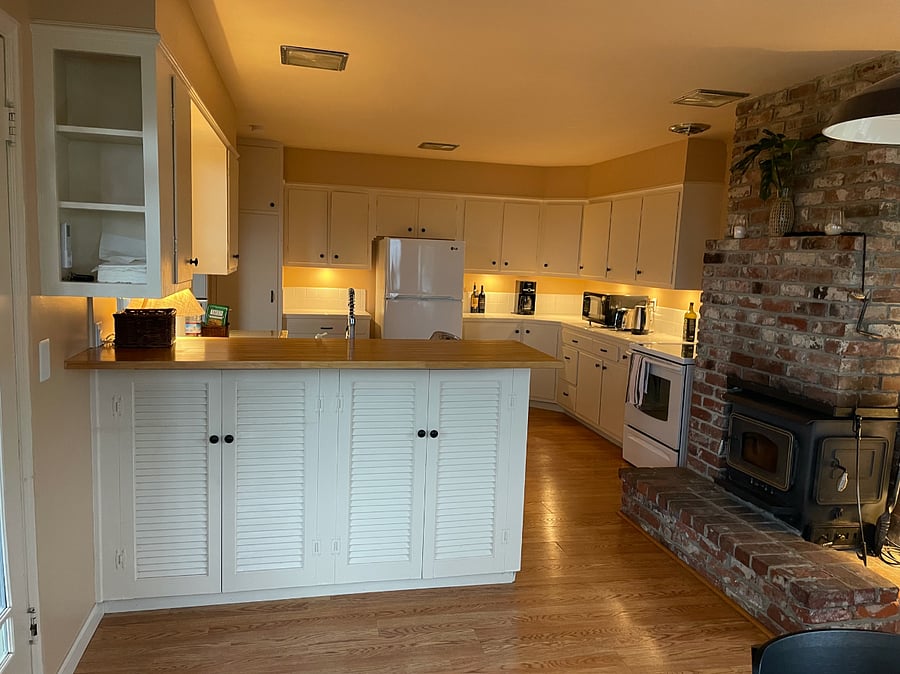 Large kitchen with plenty of counter space, storage and fireplace.  Opens out to lower patio. 