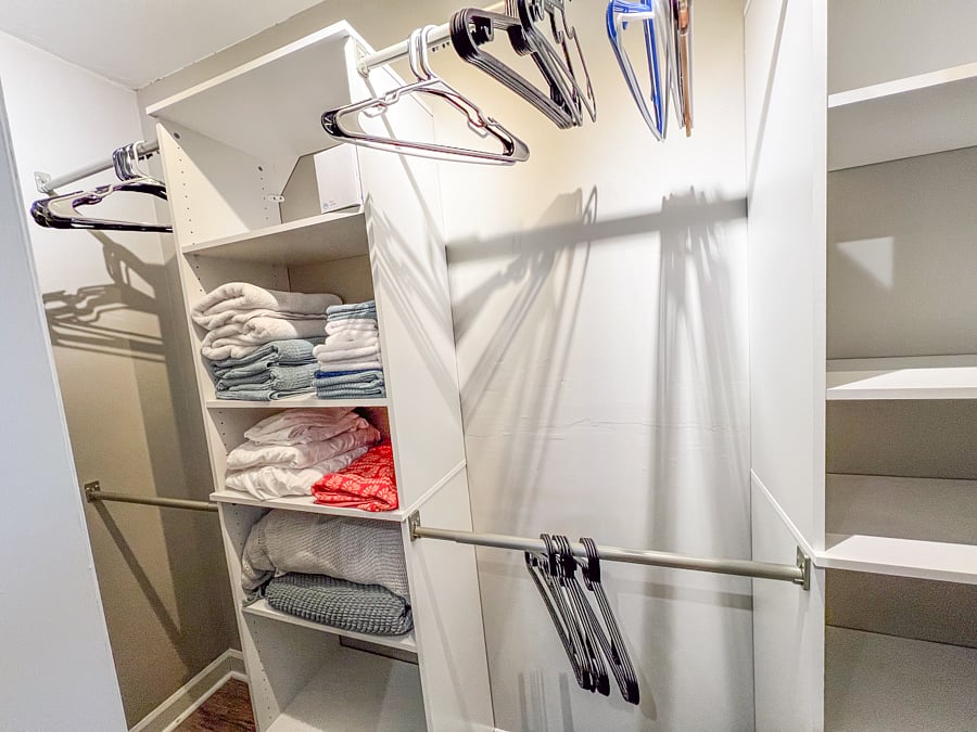 Closet in the bedroom with ample space, spare bed linens, towels, washcloths and hangers.
