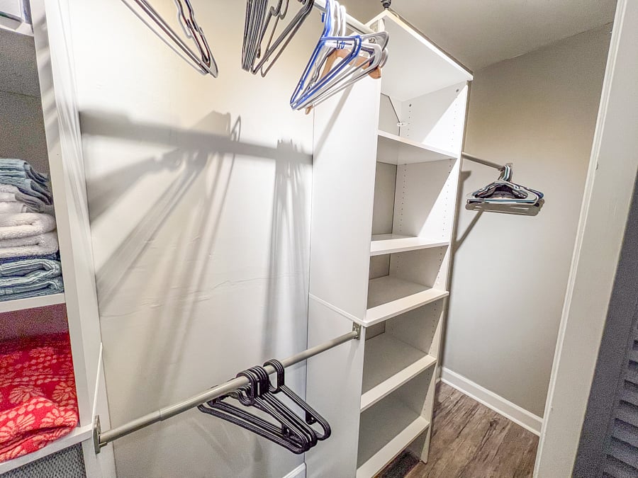Closet in the bedroom with ample space, spare bed linens, towels, washcloths and hangers.