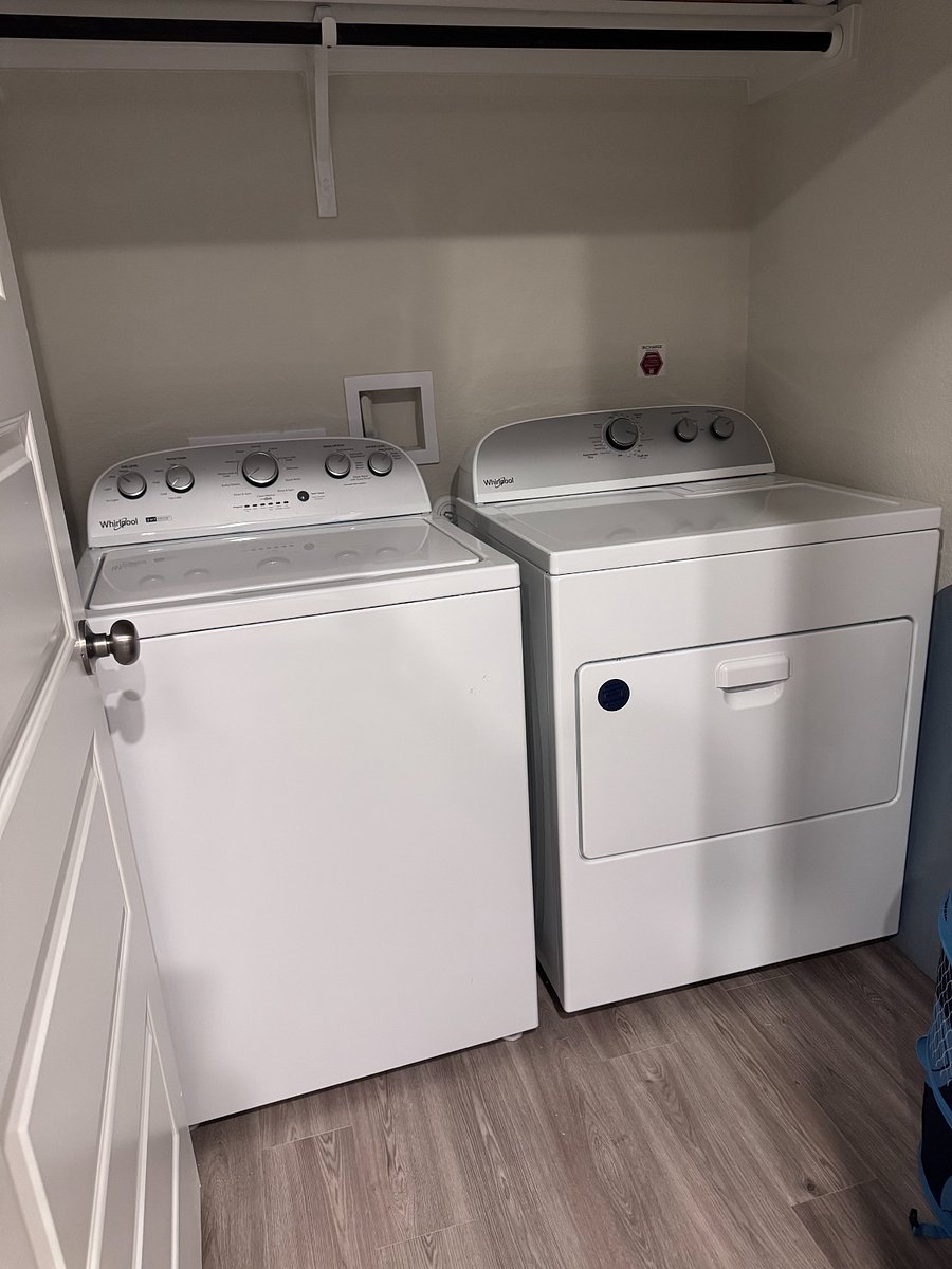 In unit washer and dryer with iron and ironing board on first floor off of the kitchen.